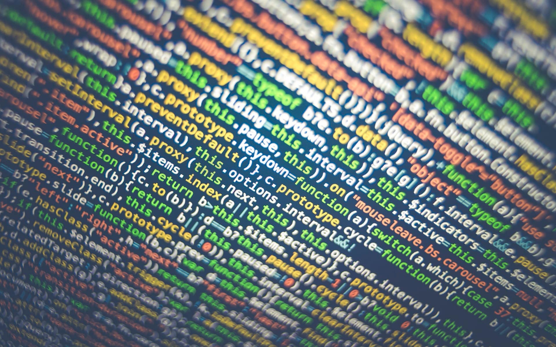 Syntax-highlighted source code filling a screen, seen at an angle so the lines recede.