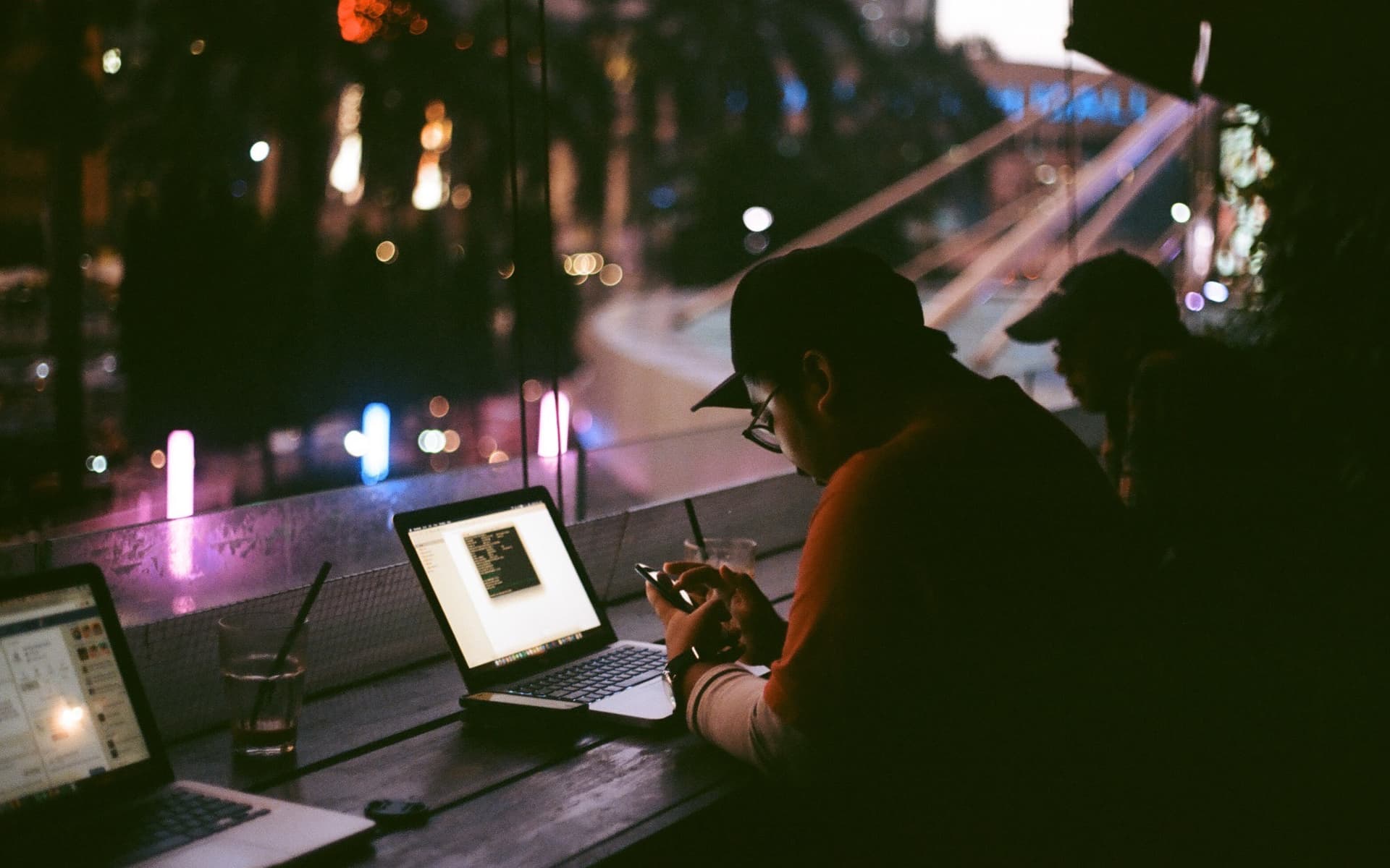 Someone working on a laptop late at night, the screen the only bright thing in a dark room.