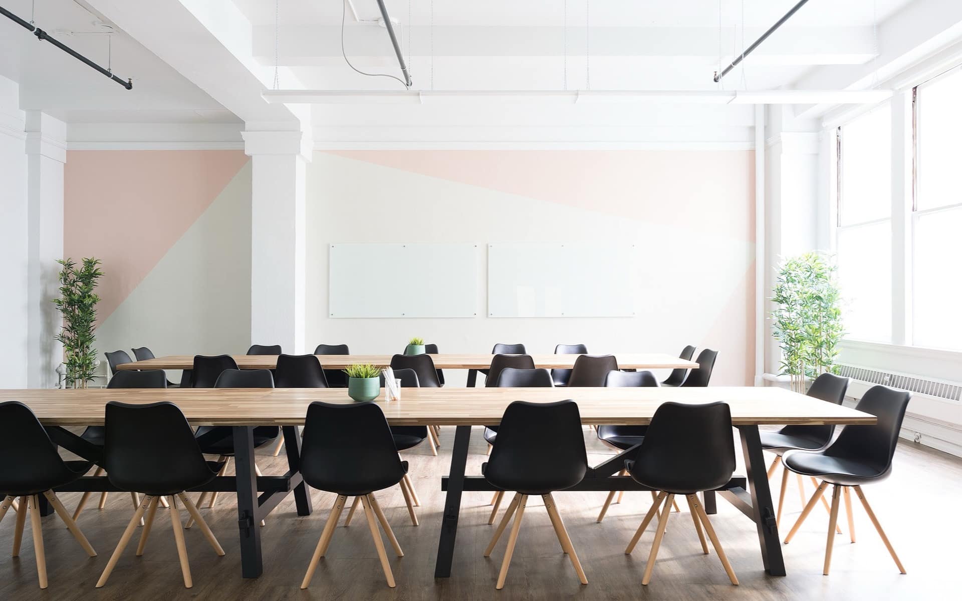 A long meeting table set with chairs in a bright, empty boardroom.