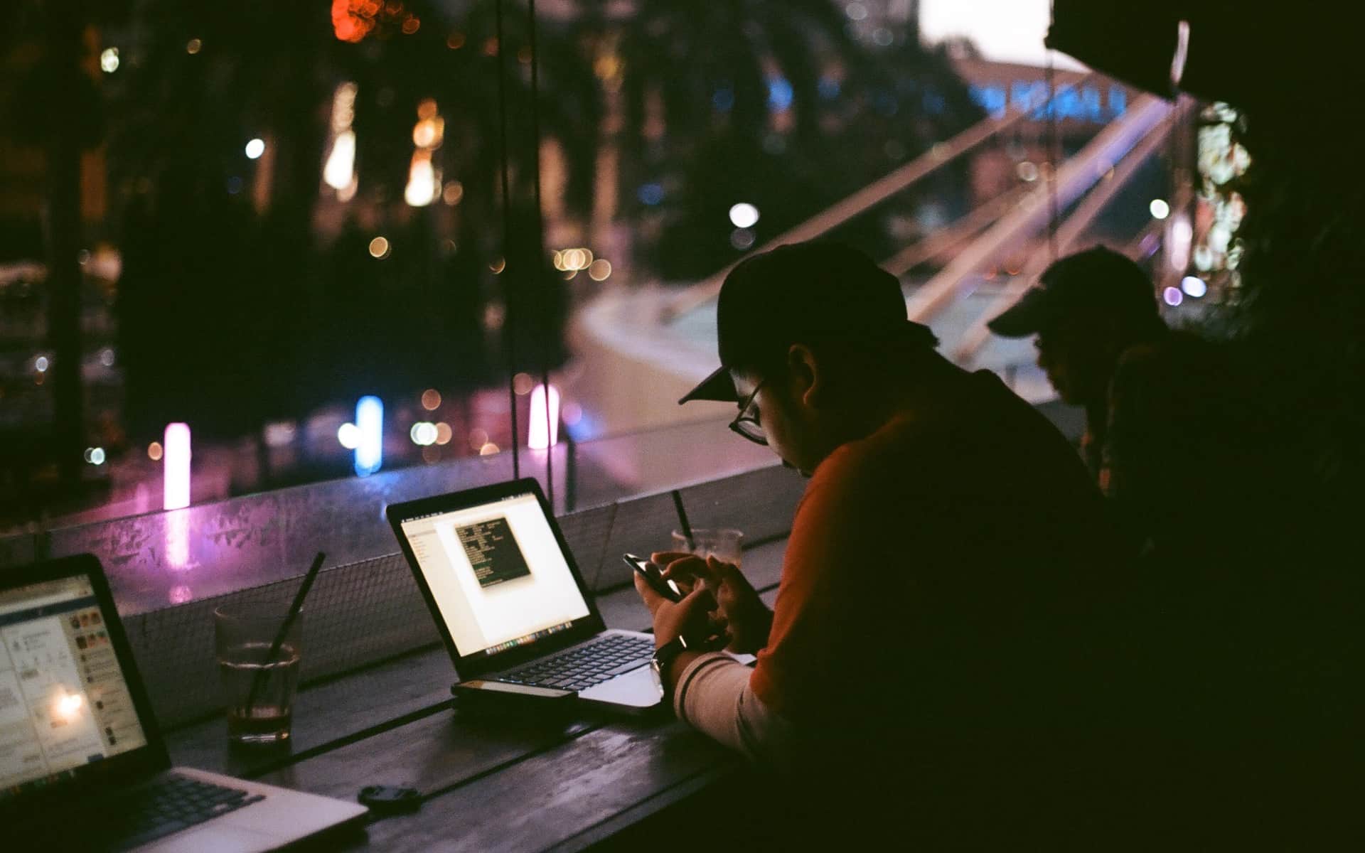 Someone working on a laptop late at night, the screen the only bright thing in a dark room.