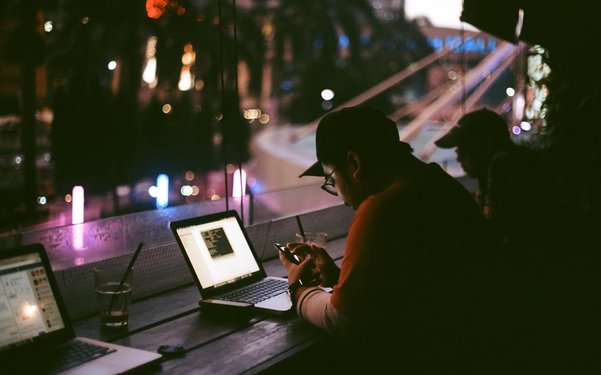 Someone working on a laptop late at night, the screen the only bright thing in a dark room.