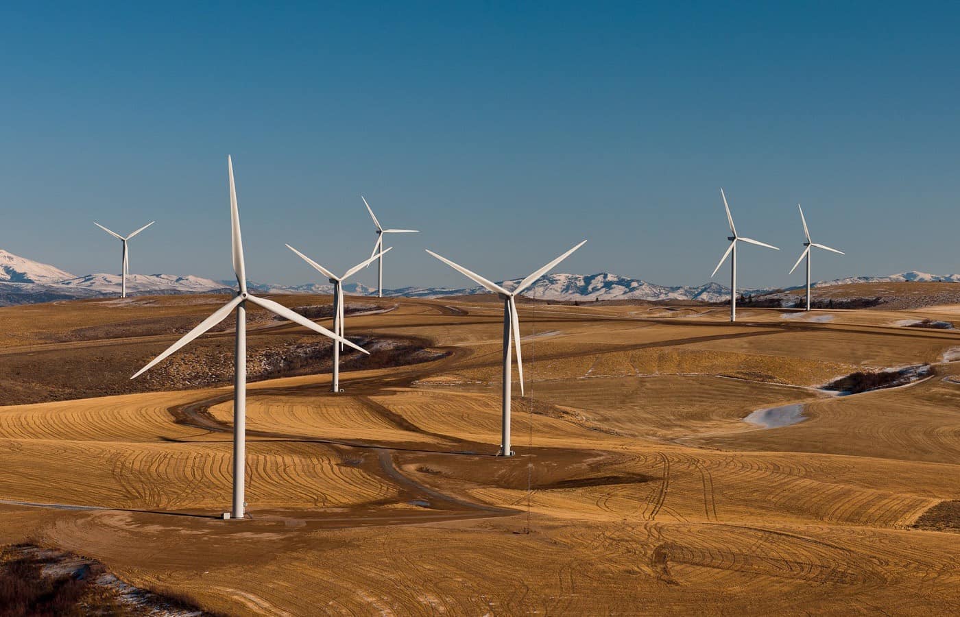 Wind turbines spread across open high ground, seen from the air.
