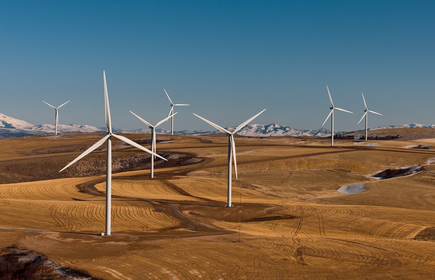 Wind turbines spread across open high ground, seen from the air.